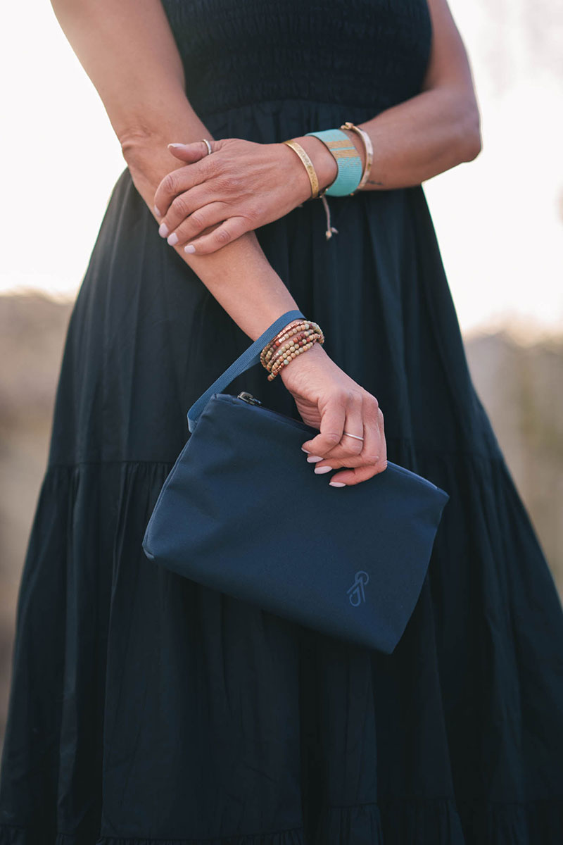 woman holding black smmt clutch