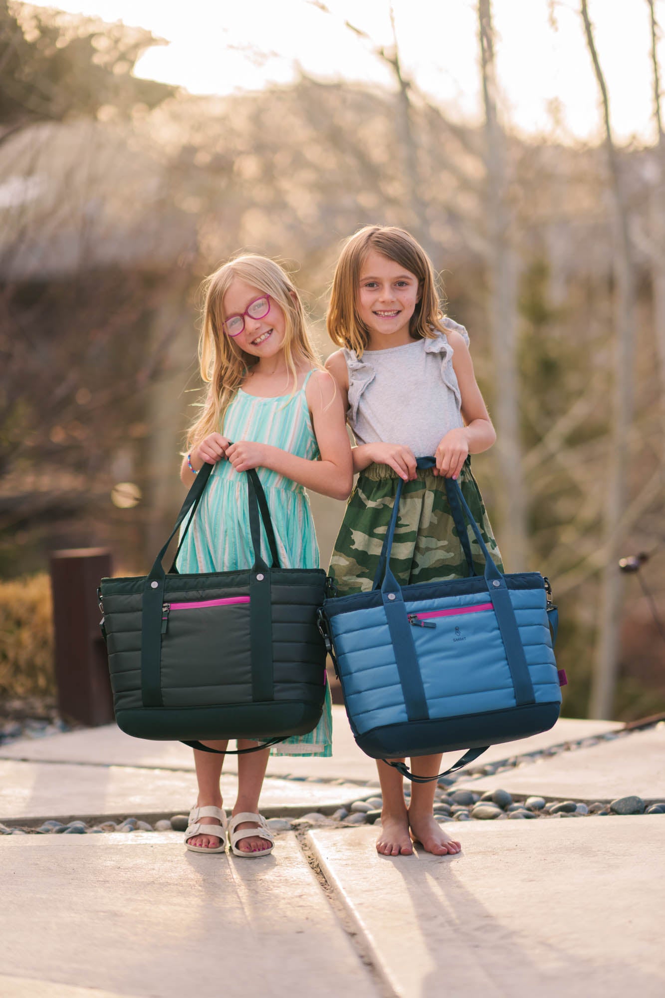 two young girls holding smmt tote bags