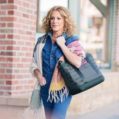 Woman carrying black 20 liter tote bag over her arm in park city